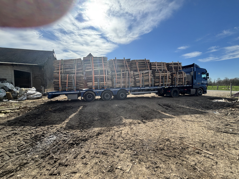 Chargement de bois sur un camion près du bâtiment de stockage